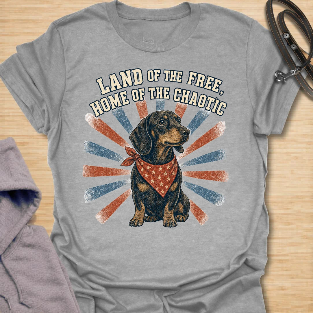 This Land Of The Free Home Of The Chaotic t-shirt is made for dachshund lovers who know their little long dog brings big energy everywhere they go. Featuring a black and tan doxie with a red bandana, vintage patriotic-style rays, and bold distressed text, this funny dog design is great for dachshund moms, dachshund dads, wiener dog fans, rescue dog lovers, and anyone whose home is proudly ruled by dachshund chaos.