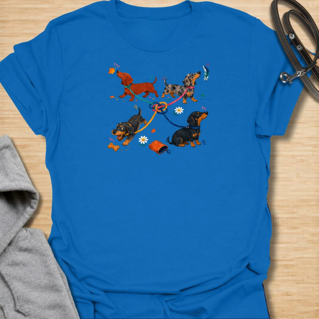 Celebrate the lovable chaos of walking multiple dachshunds with this playful graphic T-shirt. Featuring four sausage dogs, tangled leashes, scattered treats, and plenty of personality, it is perfect for dachshund owners and dog lovers. A fun everyday tee and a thoughtful gift for anyone whose dog walks never go quite to plan.