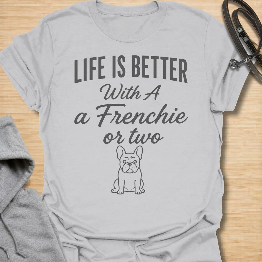 This Life Is Better With A Frenchie Or Two t-shirt is made for French Bulldog lovers who know one Frenchie is wonderful, but two is even better. Featuring a simple Frenchie illustration with clean mixed typography, this design has a sweet, easy-to-wear dog-parent feel for everyday style. Perfect for Frenchie moms, Frenchie dads, French Bulldog owners, rescue dog lovers, and anyone whose life is happier with a little Frenchie chaos.