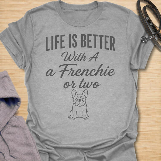 This Life Is Better With A Frenchie Or Two t-shirt is made for French Bulldog lovers who know one Frenchie is wonderful, but two is even better. Featuring a simple Frenchie illustration with clean mixed typography, this design has a sweet, easy-to-wear dog-parent feel for everyday style. Perfect for Frenchie moms, Frenchie dads, French Bulldog owners, rescue dog lovers, and anyone whose life is happier with a little Frenchie chaos.