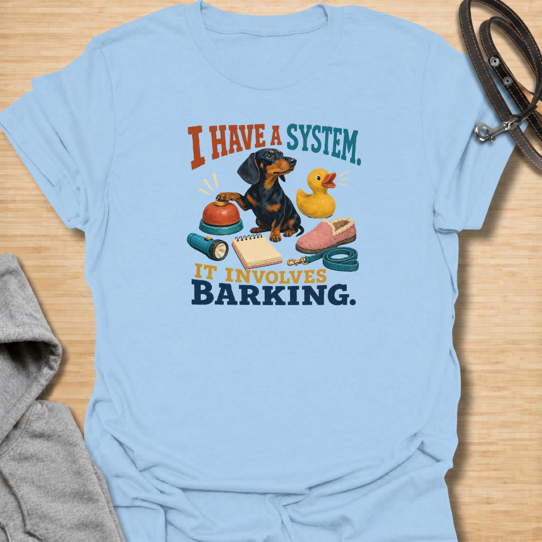 Every dachshund has a system—and it usually involves barking. This funny dachshund T-shirt features a determined sausage dog surrounded by its essential barking equipment, making it perfect for doxie owners who know the routine. A playful everyday tee and a fun gift for dachshund moms, dads, and devoted dog lovers.