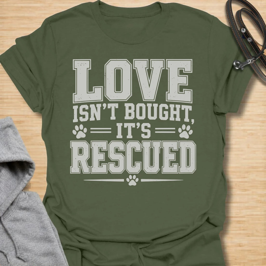 This Love Isn’t Bought, It’s Rescued t-shirt is made for rescue dog lovers who believe the best dogs are found through adoption and second chances. Featuring bold varsity-style lettering with paw print accents, this design has a simple, meaningful rescue-dog message that is easy to wear every day. Perfect for rescue dog moms, rescue dog dads, shelter dog adopters, foster families, animal lovers, and anyone who proudly supports dog rescue. Military Green