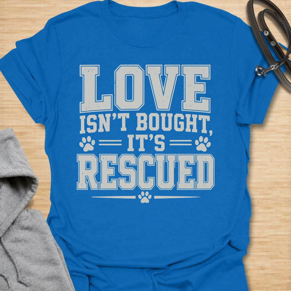 This Love Isn’t Bought, It’s Rescued t-shirt is made for rescue dog lovers who believe the best dogs are found through adoption and second chances. Featuring bold varsity-style lettering with paw print accents, this design has a simple, meaningful rescue-dog message that is easy to wear every day. Perfect for rescue dog moms, rescue dog dads, shelter dog adopters, foster families, animal lovers, and anyone who proudly supports dog rescue. Royal