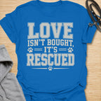 This Love Isn’t Bought, It’s Rescued t-shirt is made for rescue dog lovers who believe the best dogs are found through adoption and second chances. Featuring bold varsity-style lettering with paw print accents, this design has a simple, meaningful rescue-dog message that is easy to wear every day. Perfect for rescue dog moms, rescue dog dads, shelter dog adopters, foster families, animal lovers, and anyone who proudly supports dog rescue. Royal