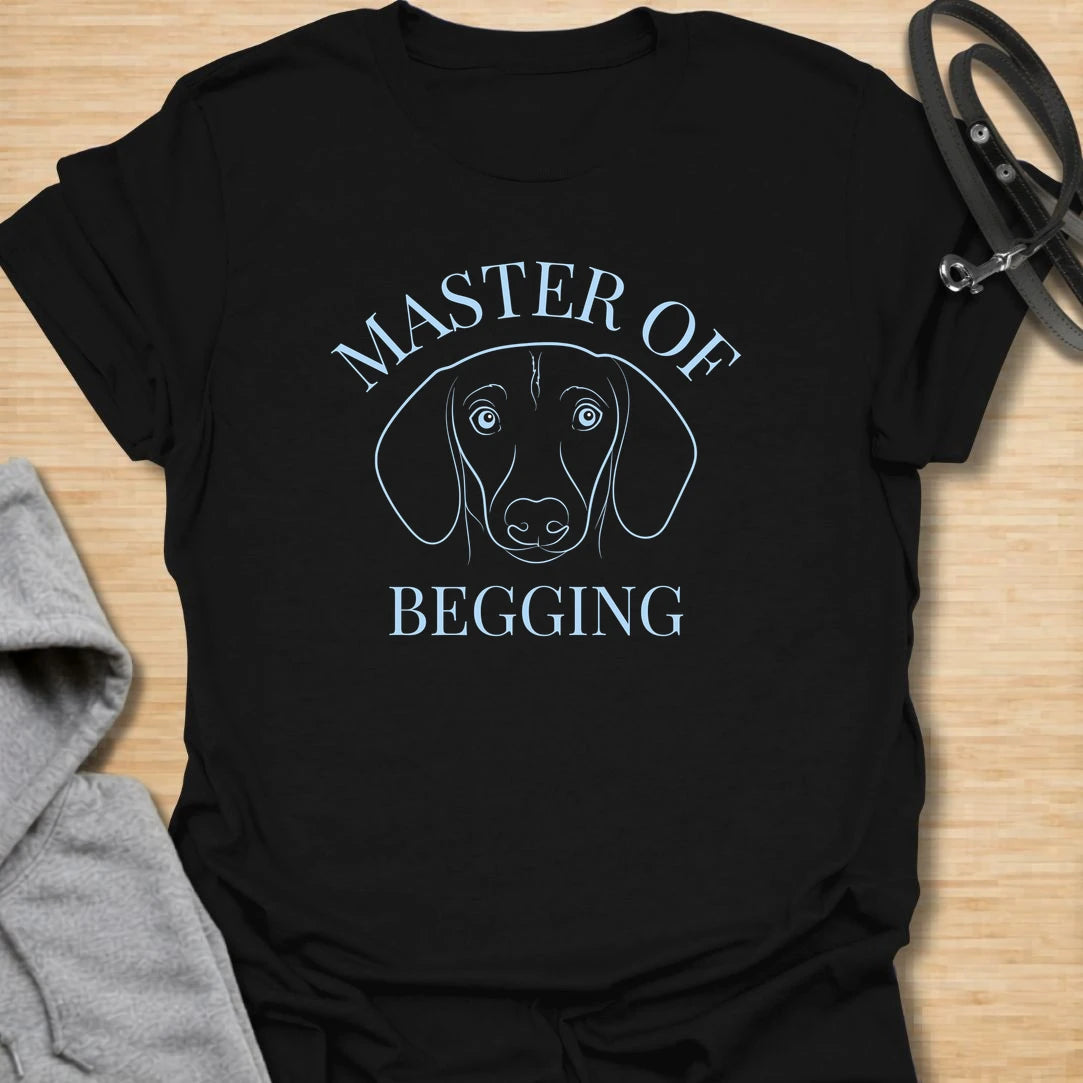 Master Of Begging t-shirt for dachshund owners who know those big doxie eyes are impossible to resist. This simple line-art dachshund design is perfect for sausage dog lovers, dog moms, and anyone whose pup has perfected the art of asking for treats. A funny gift for pet parents who live with a professional snack negotiator.