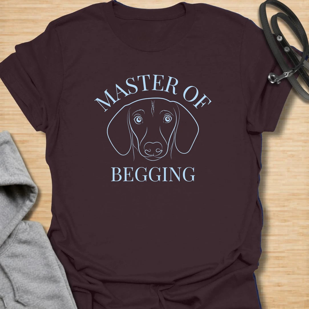 Master Of Begging t-shirt for dachshund owners who know those big doxie eyes are impossible to resist. This simple line-art dachshund design is perfect for sausage dog lovers, dog moms, and anyone whose pup has perfected the art of asking for treats. A funny gift for pet parents who live with a professional snack negotiator.