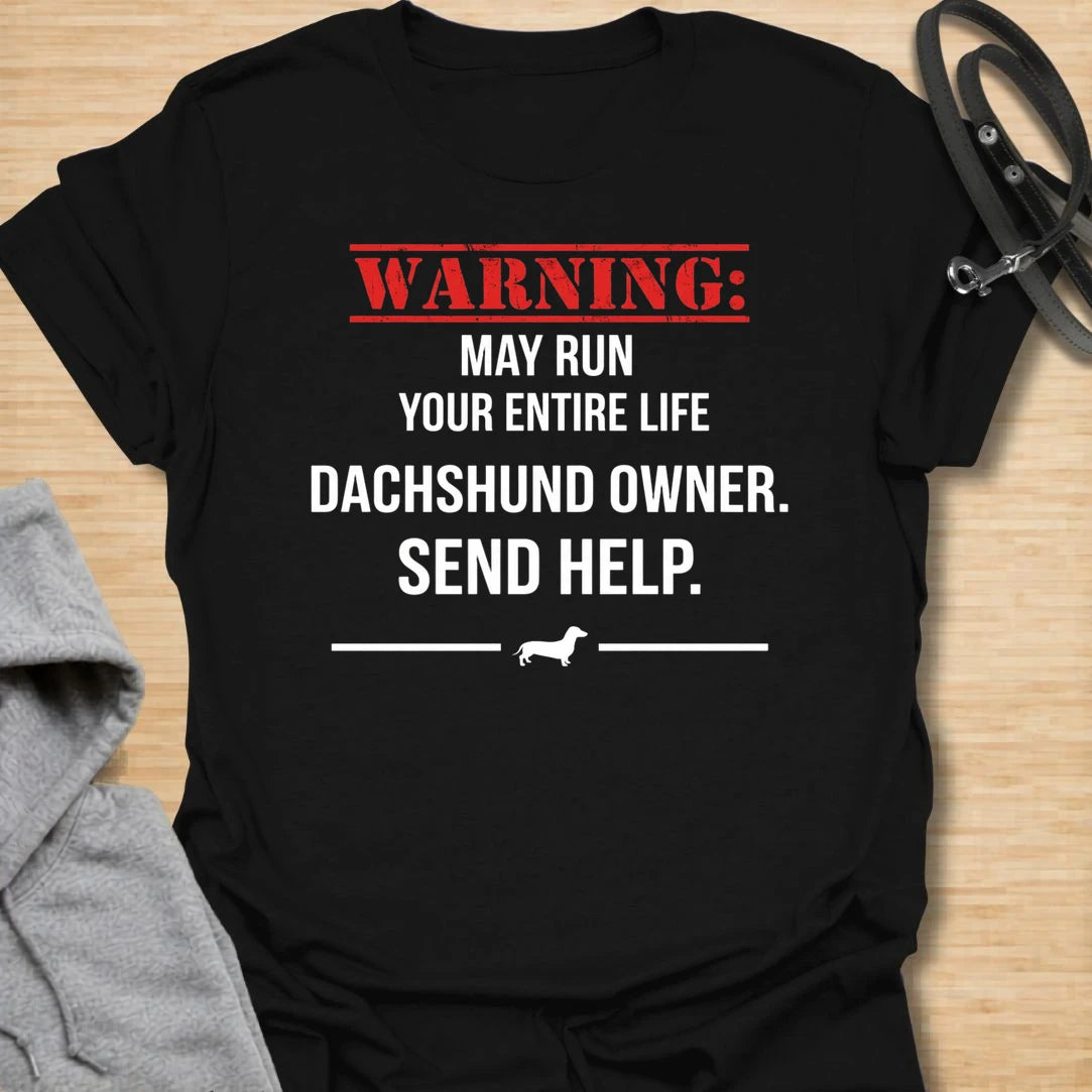 This Warning May Run Your Entire Life t-shirt is made for dachshund lovers who know their little long dog has completely taken over. Featuring bold warning-style typography, a small dachshund silhouette, and the phrase Dachshund Owner. Send Help., this design has a funny dog-parent feel that doxie owners will instantly understand. Perfect for dachshund moms, dachshund dads, wiener dog fans, rescue dog lovers, and anyone whose dachshund is absolutely in charge.