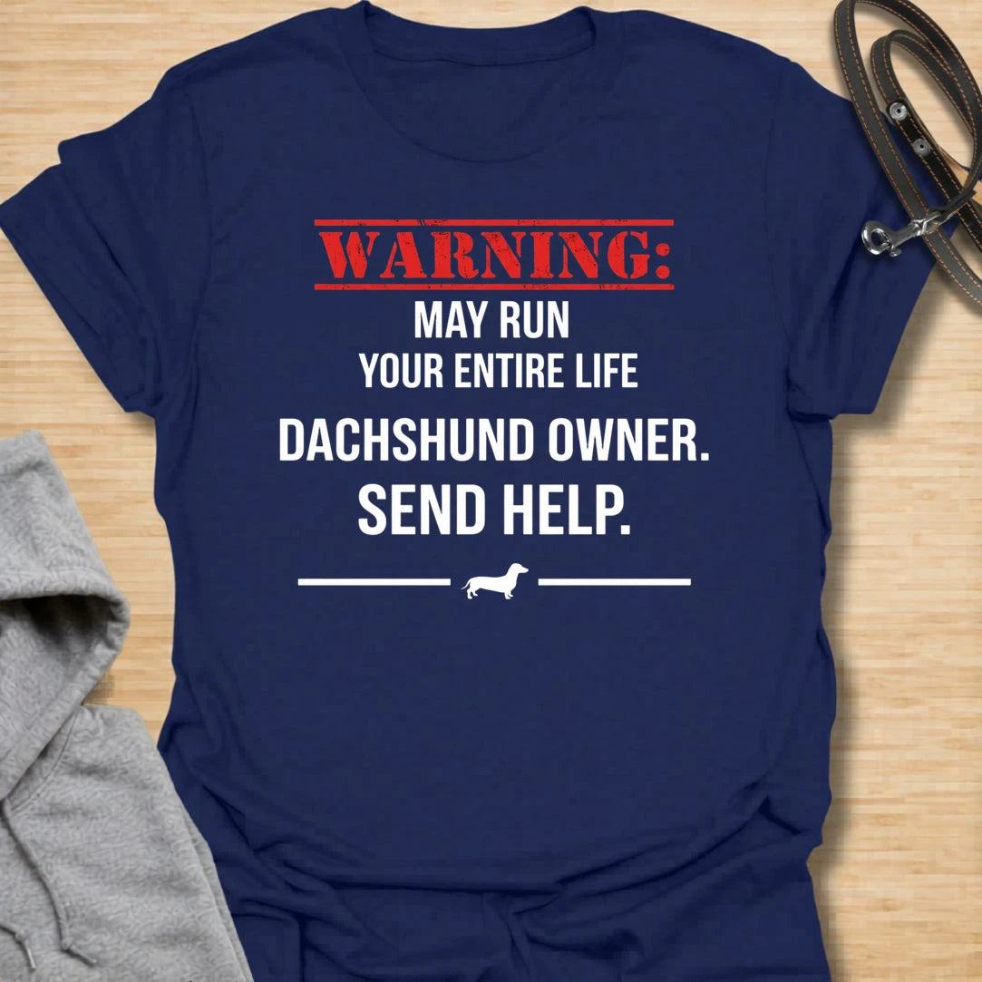 This Warning May Run Your Entire Life t-shirt is made for dachshund lovers who know their little long dog has completely taken over. Featuring bold warning-style typography, a small dachshund silhouette, and the phrase Dachshund Owner. Send Help., this design has a funny dog-parent feel that doxie owners will instantly understand. Perfect for dachshund moms, dachshund dads, wiener dog fans, rescue dog lovers, and anyone whose dachshund is absolutely in charge.