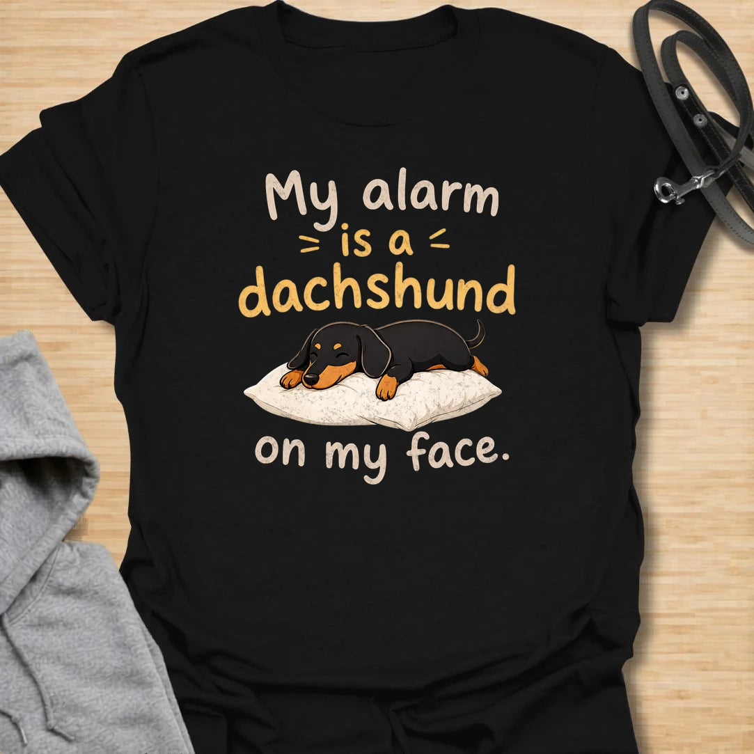 This My Alarm Is A Dachshund On My Face t-shirt is made for doxie lovers who know morning wake-up calls are not optional. Featuring a sleepy dachshund stretched across a pillow with playful text, this design has a cute and funny dog-parent feel. Perfect for dachshund moms, dachshund dads, wiener dog fans, rescue dog lovers, and anyone whose little long dog starts the day by climbing on their face.