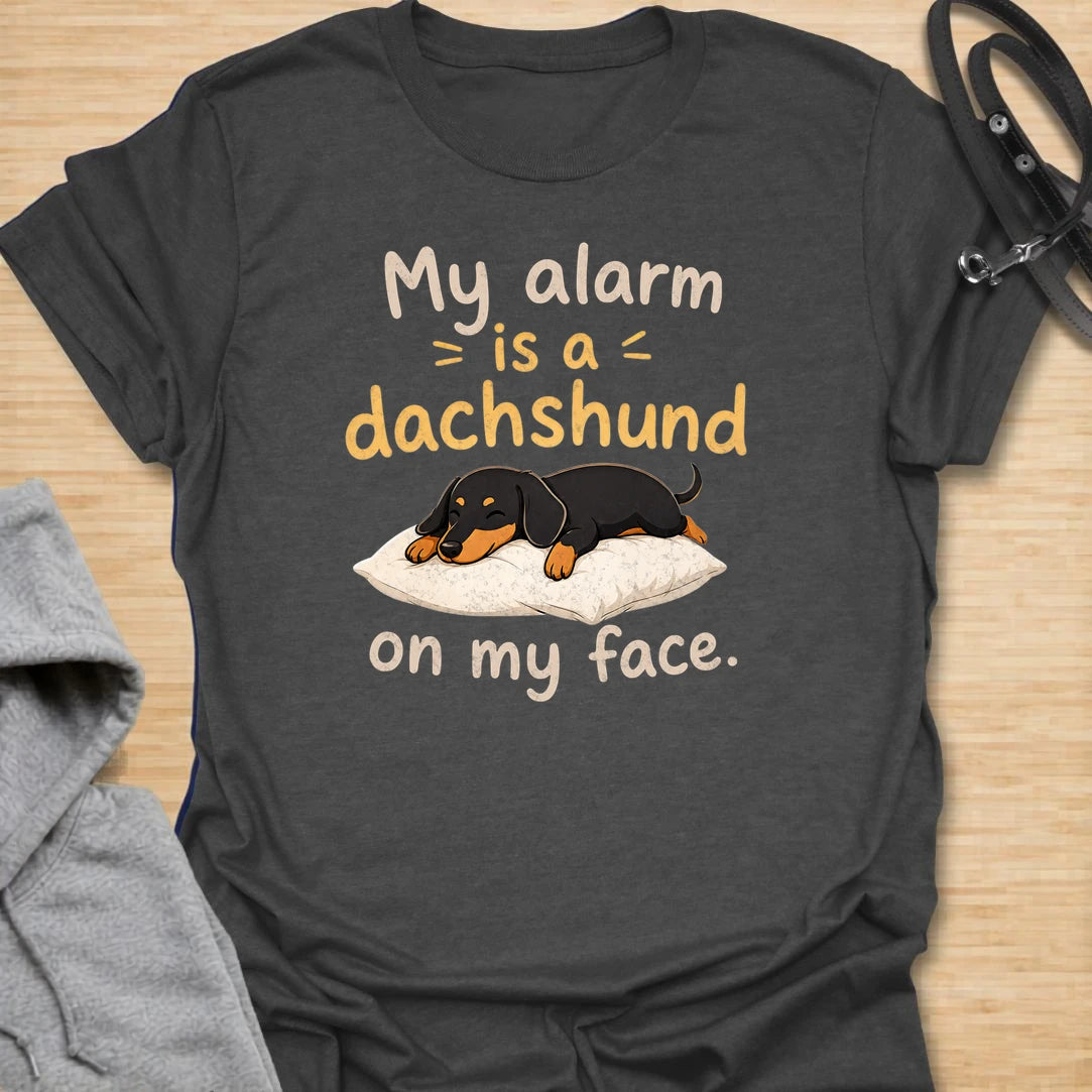 This My Alarm Is A Dachshund On My Face t-shirt is made for doxie lovers who know morning wake-up calls are not optional. Featuring a sleepy dachshund stretched across a pillow with playful text, this design has a cute and funny dog-parent feel. Perfect for dachshund moms, dachshund dads, wiener dog fans, rescue dog lovers, and anyone whose little long dog starts the day by climbing on their face.