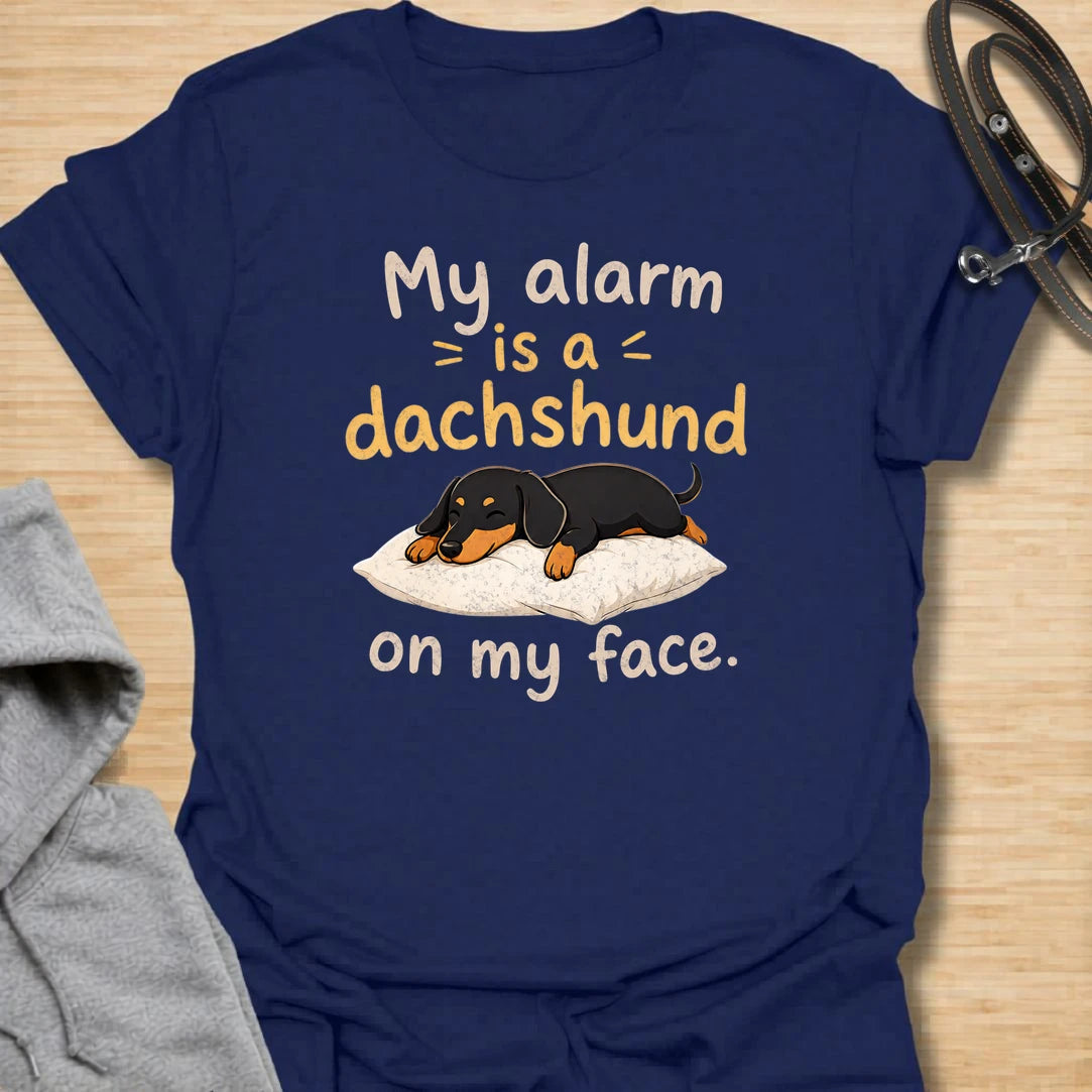 This My Alarm Is A Dachshund On My Face t-shirt is made for doxie lovers who know morning wake-up calls are not optional. Featuring a sleepy dachshund stretched across a pillow with playful text, this design has a cute and funny dog-parent feel. Perfect for dachshund moms, dachshund dads, wiener dog fans, rescue dog lovers, and anyone whose little long dog starts the day by climbing on their face.
