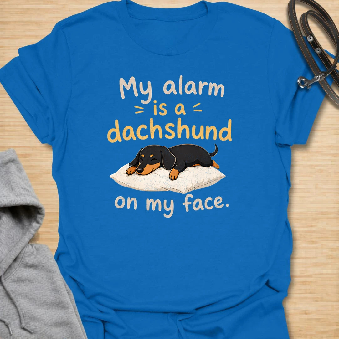 This My Alarm Is A Dachshund On My Face t-shirt is made for doxie lovers who know morning wake-up calls are not optional. Featuring a sleepy dachshund stretched across a pillow with playful text, this design has a cute and funny dog-parent feel. Perfect for dachshund moms, dachshund dads, wiener dog fans, rescue dog lovers, and anyone whose little long dog starts the day by climbing on their face.