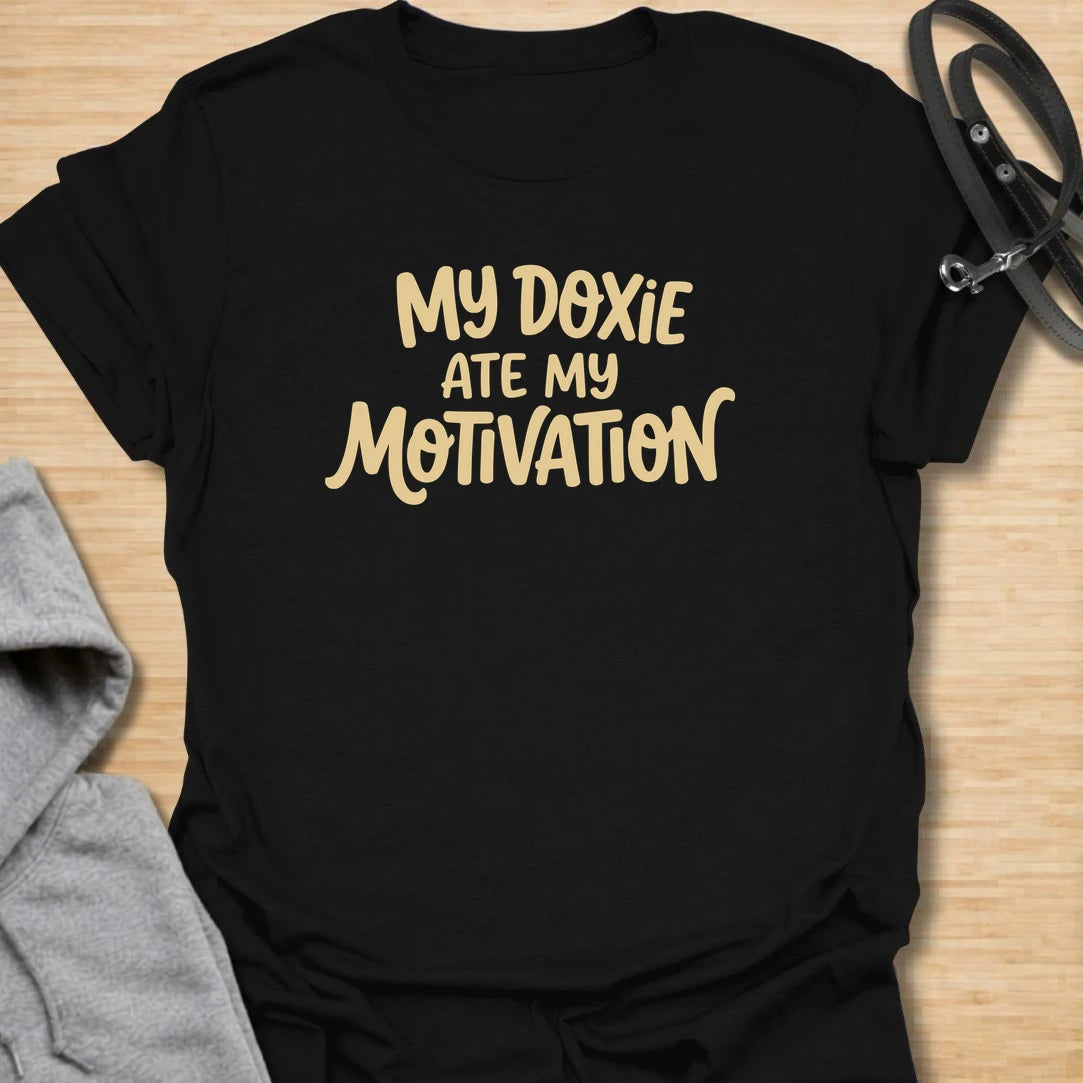Doxie Motivation t-shirt for dachshund lovers who blame their sausage dog for every lazy day, missed chore, and cozy nap. The playful text reads “My Doxie Ate My Motivation,” making it a funny choice for doxie moms, dog owners, and anyone whose dachshund runs the household. A relatable gift for dog people with a lazy little sidekick.