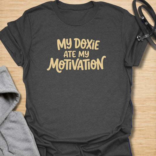 Doxie Motivation t-shirt for dachshund lovers who blame their sausage dog for every lazy day, missed chore, and cozy nap. The playful text reads “My Doxie Ate My Motivation,” making it a funny choice for doxie moms, dog owners, and anyone whose dachshund runs the household. A relatable gift for dog people with a lazy little sidekick.