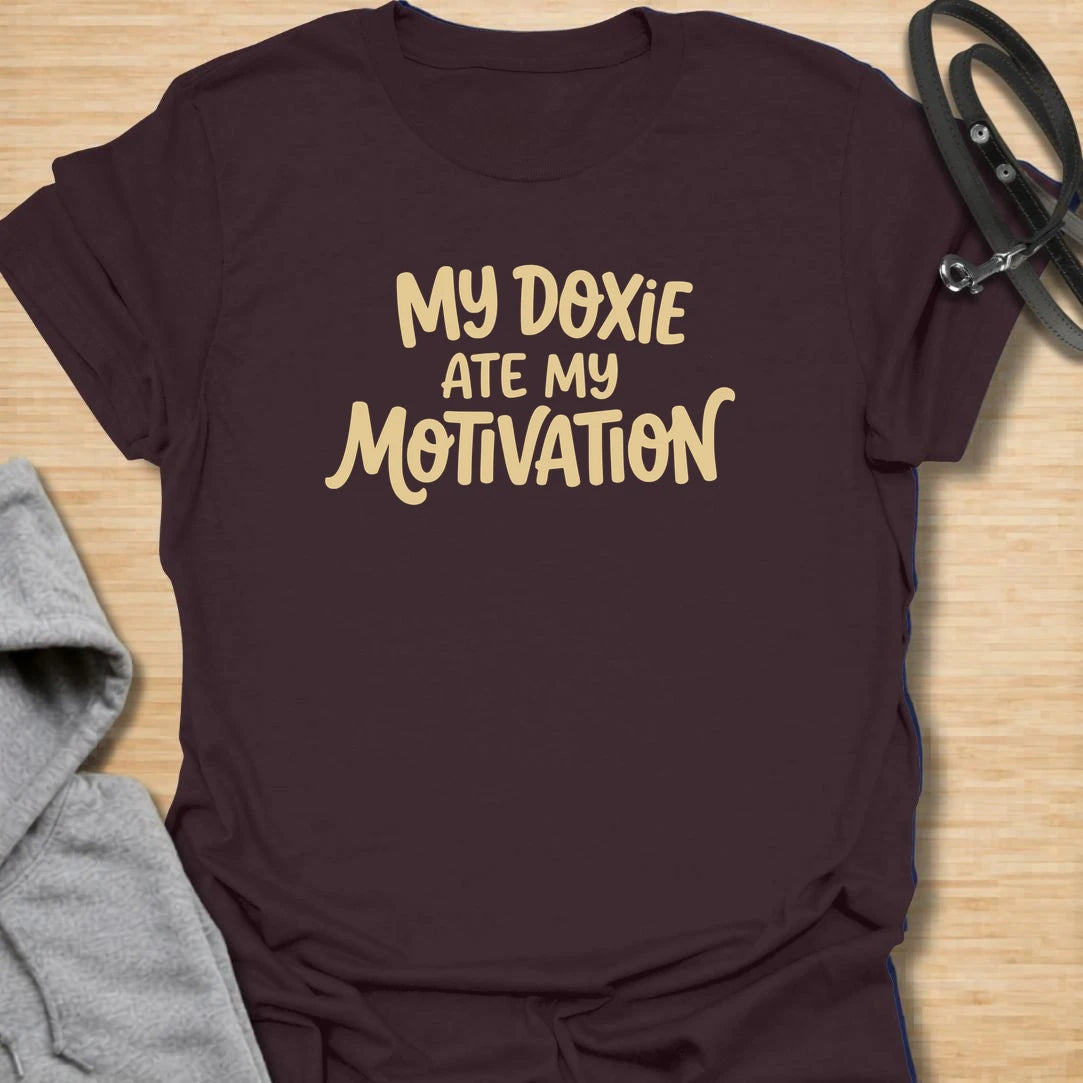 Doxie Motivation t-shirt for dachshund lovers who blame their sausage dog for every lazy day, missed chore, and cozy nap. The playful text reads “My Doxie Ate My Motivation,” making it a funny choice for doxie moms, dog owners, and anyone whose dachshund runs the household. A relatable gift for dog people with a lazy little sidekick.