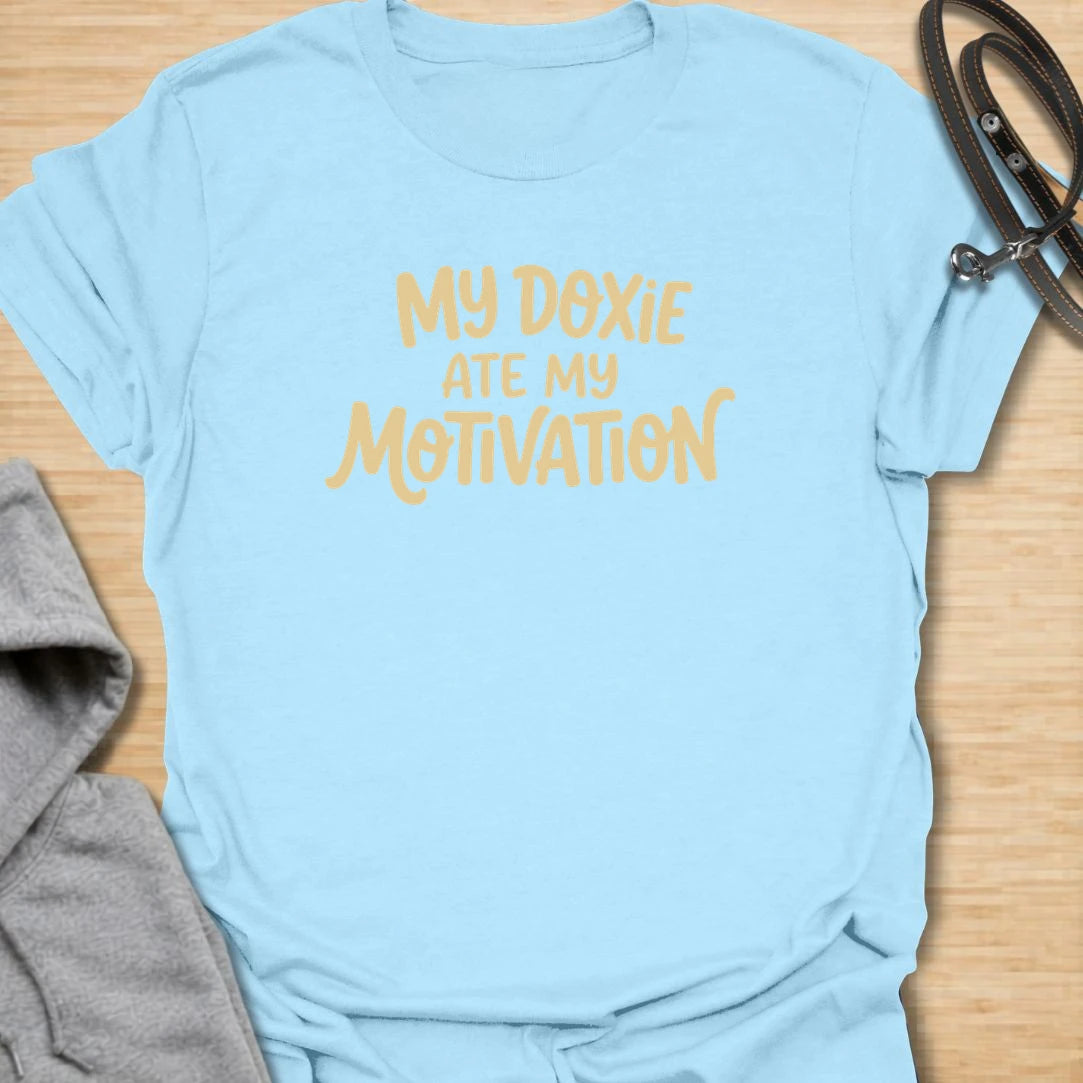 Doxie Motivation t-shirt for dachshund lovers who blame their sausage dog for every lazy day, missed chore, and cozy nap. The playful text reads “My Doxie Ate My Motivation,” making it a funny choice for doxie moms, dog owners, and anyone whose dachshund runs the household. A relatable gift for dog people with a lazy little sidekick.