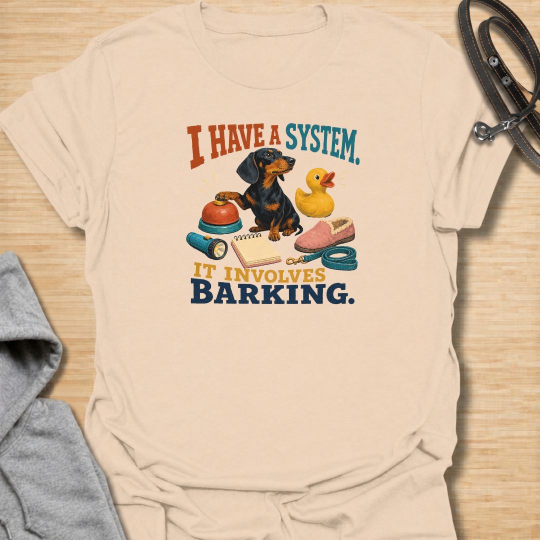 Every dachshund has a system—and it usually involves barking. This funny dachshund T-shirt features a determined sausage dog surrounded by its essential barking equipment, making it perfect for doxie owners who know the routine. A playful everyday tee and a fun gift for dachshund moms, dads, and devoted dog lovers.