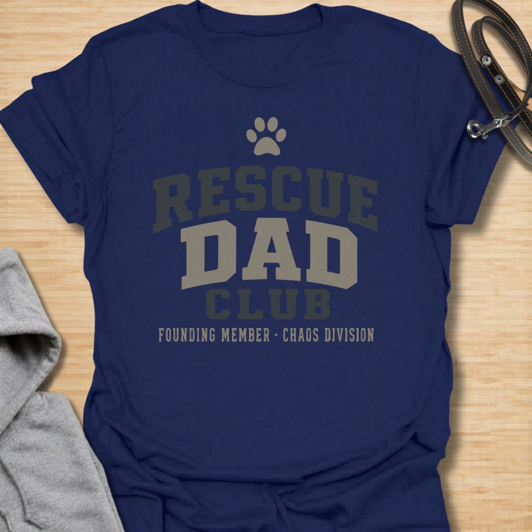 This Rescue Dad Club t-shirt is made for proud dog dads who know rescue dogs bring love, loyalty, and just the right amount of chaos. Featuring bold varsity-style lettering, a paw print, bone accents, and the phrase founding member chaos division, this design has a clean sporty look with a funny rescue-dog twist. Perfect for rescue dog dads, foster dog dads, shelter dog adopters, dog lovers, and anyone proudly raising a second-chance pup.