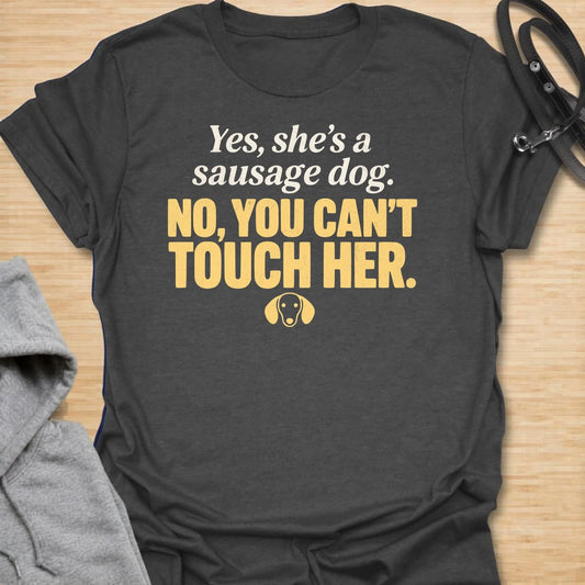 This No You Can’t Touch Her t-shirt is made for dachshund lovers who know their little sausage dog may be cute, but personal space is non-negotiable. Featuring bold text-only typography, a small dachshund face icon, and a funny protective dog-parent message, this design has a simple, attitude-filled feel that doxie owners will instantly understand. Perfect for dachshund moms, dachshund dads, wiener dog fans, rescue dog lovers, anxious dog owners, and anyone whose tiny long dog chooses who gets close.