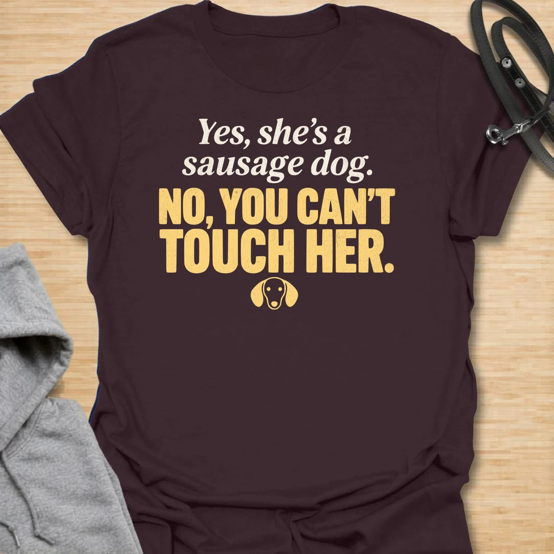 This No You Can’t Touch Her t-shirt is made for dachshund lovers who know their little sausage dog may be cute, but personal space is non-negotiable. Featuring bold text-only typography, a small dachshund face icon, and a funny protective dog-parent message, this design has a simple, attitude-filled feel that doxie owners will instantly understand. Perfect for dachshund moms, dachshund dads, wiener dog fans, rescue dog lovers, anxious dog owners, and anyone whose tiny long dog chooses who gets close.