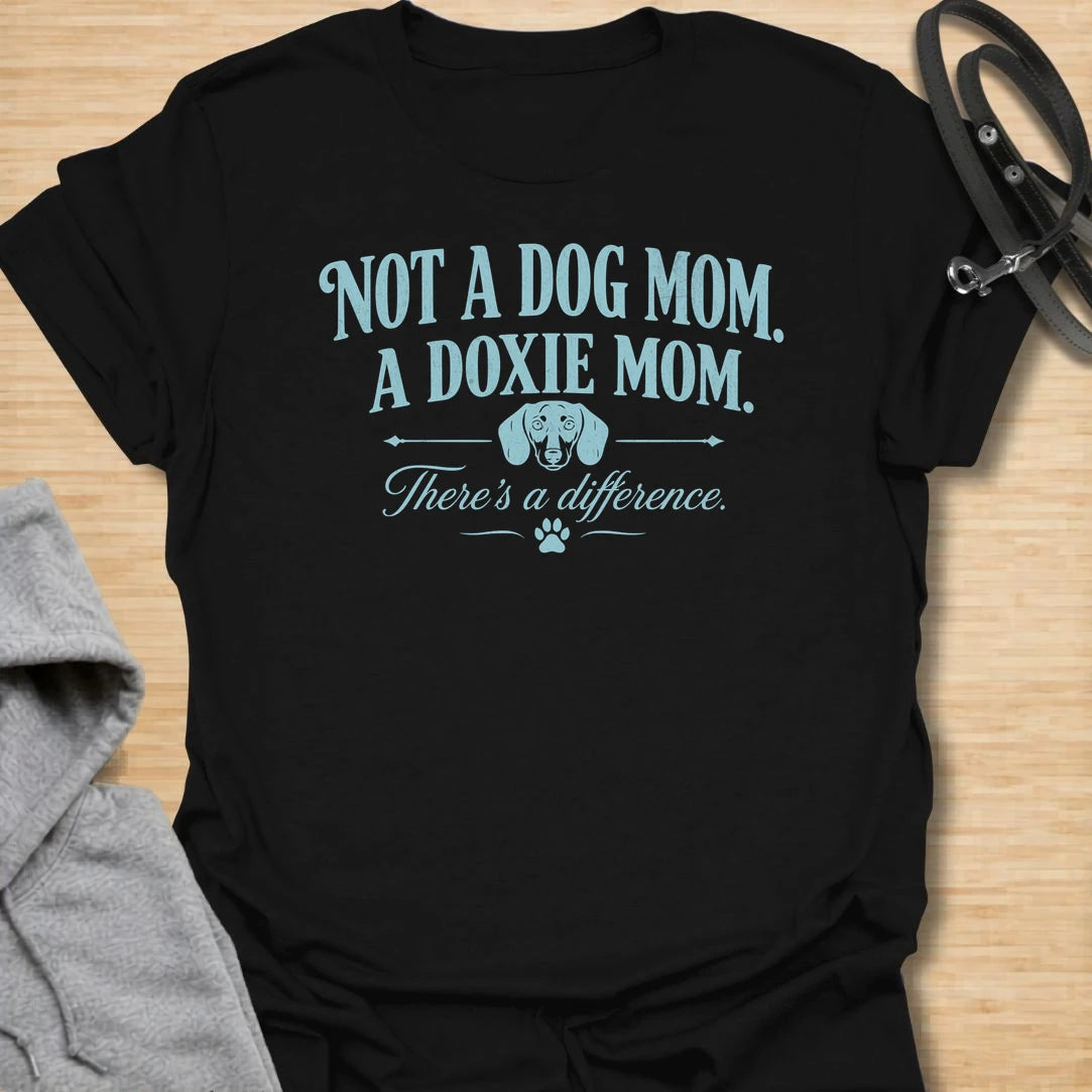 This Not A Dog Mom A Doxie Mom t-shirt is made for dachshund lovers who know there is definitely a difference. Featuring vintage-style typography, a small dachshund accent, paw print details, and a funny breed-specific message, this design has a simple dog-parent feel that doxie owners will instantly understand. Perfect for dachshund moms, wiener dog fans, sausage dog lovers, rescue dog owners, and anyone proudly living the doxie mom life.