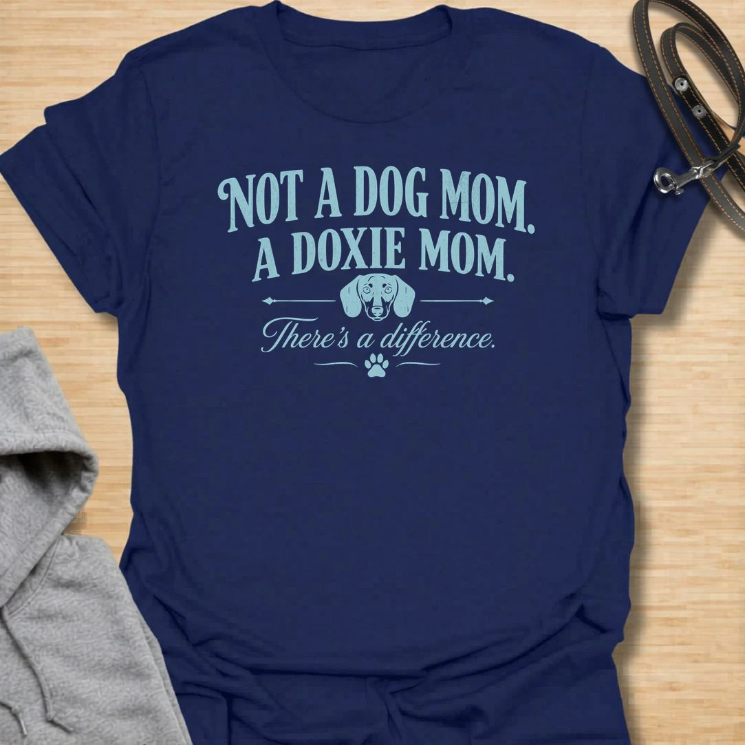 This Not A Dog Mom A Doxie Mom t-shirt is made for dachshund lovers who know there is definitely a difference. Featuring vintage-style typography, a small dachshund accent, paw print details, and a funny breed-specific message, this design has a simple dog-parent feel that doxie owners will instantly understand. Perfect for dachshund moms, wiener dog fans, sausage dog lovers, rescue dog owners, and anyone proudly living the doxie mom life.