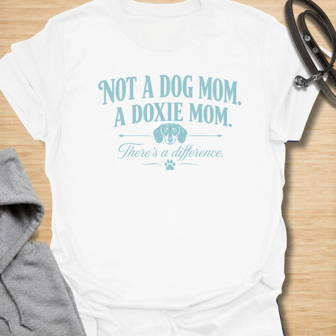 This Not A Dog Mom A Doxie Mom t-shirt is made for dachshund lovers who know there is definitely a difference. Featuring vintage-style typography, a small dachshund accent, paw print details, and a funny breed-specific message, this design has a simple dog-parent feel that doxie owners will instantly understand. Perfect for dachshund moms, wiener dog fans, sausage dog lovers, rescue dog owners, and anyone proudly living the doxie mom life.