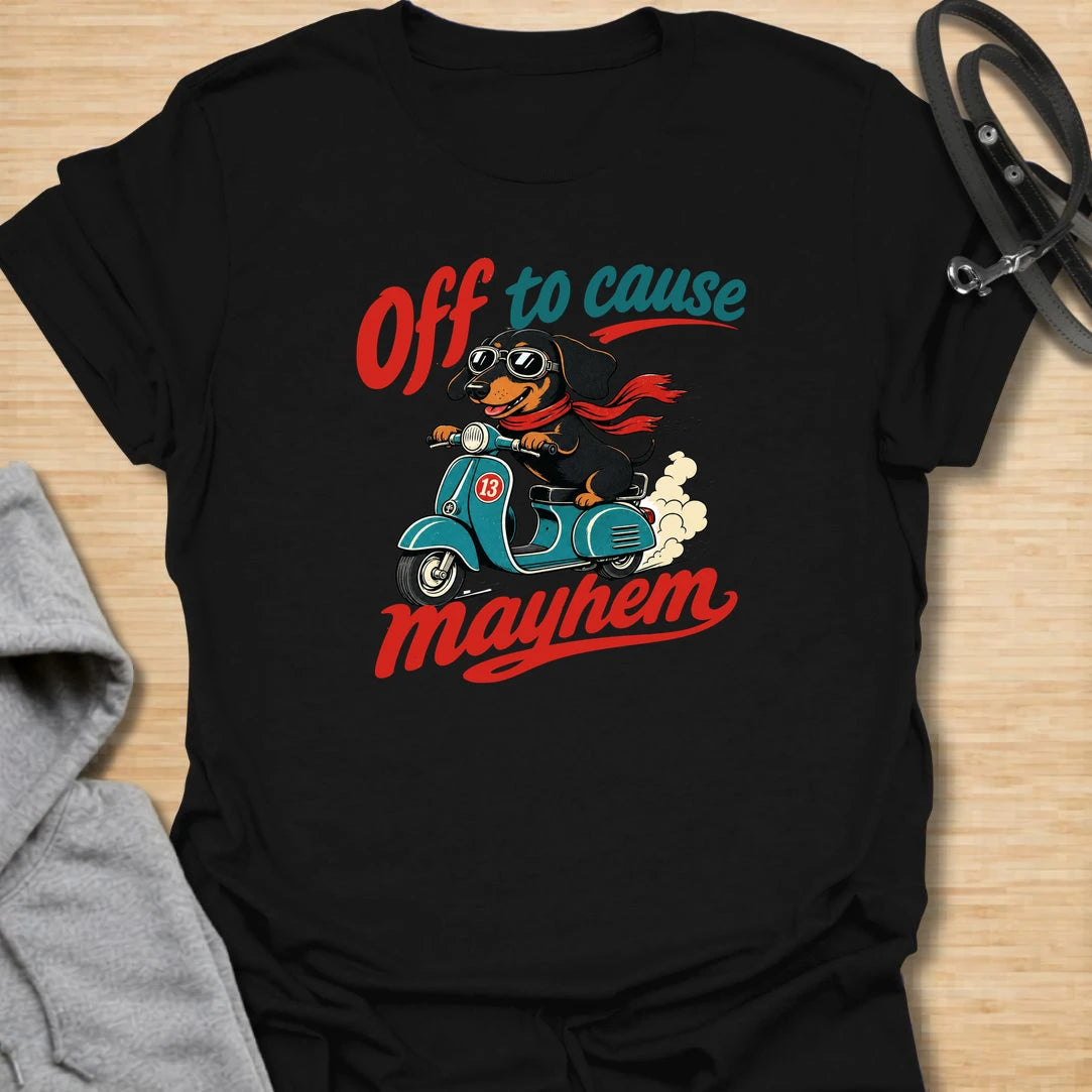 Off To Cause Mayhem t-shirt for dachshund lovers who know their doxie is always ready for mischief, speed, and drama. This funny design features a black and tan dachshund riding a scooter with sunglasses, a red scarf, and bold retro text. Perfect for sausage dog fans, doxie moms, and anyone who loves chaotic little dogs with big personalities.