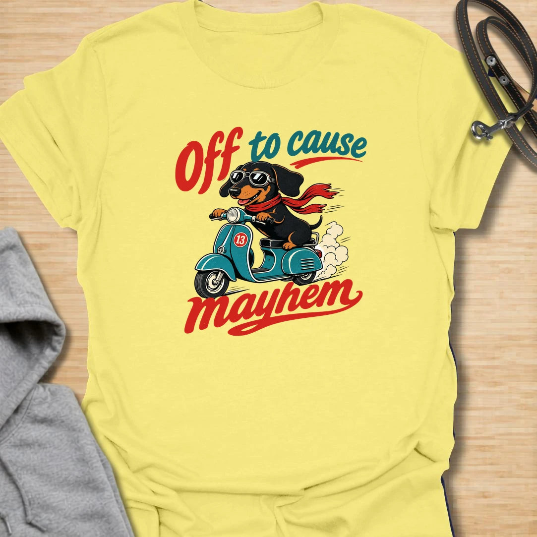 Off To Cause Mayhem t-shirt for dachshund lovers who know their doxie is always ready for mischief, speed, and drama. This funny design features a black and tan dachshund riding a scooter with sunglasses, a red scarf, and bold retro text. Perfect for sausage dog fans, doxie moms, and anyone who loves chaotic little dogs with big personalities.