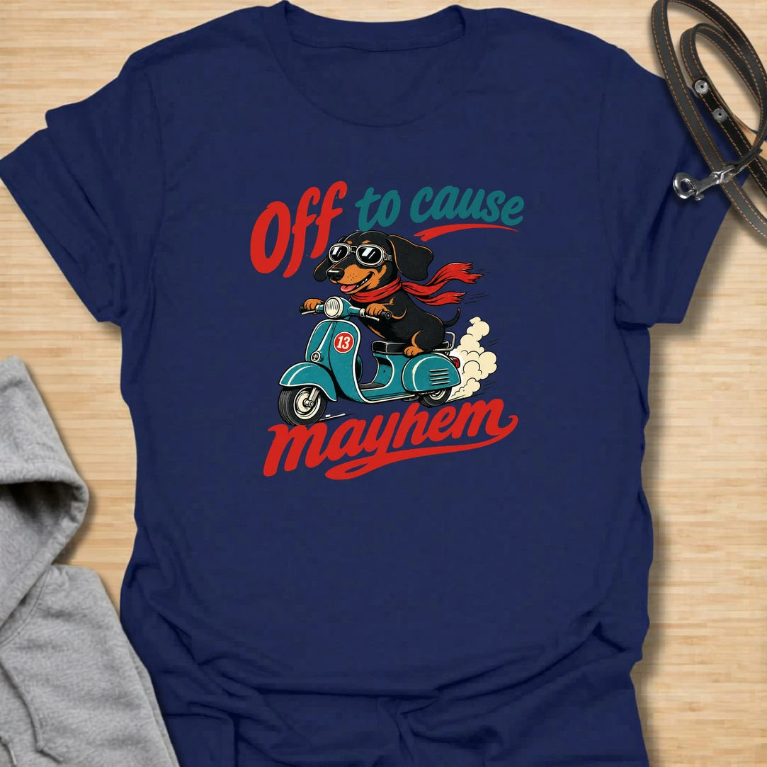 Off To Cause Mayhem t-shirt for dachshund lovers who know their doxie is always ready for mischief, speed, and drama. This funny design features a black and tan dachshund riding a scooter with sunglasses, a red scarf, and bold retro text. Perfect for sausage dog fans, doxie moms, and anyone who loves chaotic little dogs with big personalities.