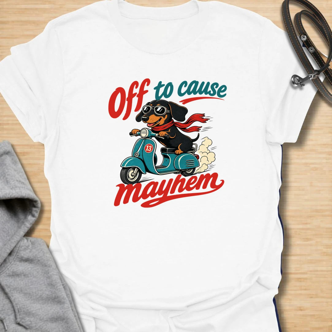 Off To Cause Mayhem t-shirt for dachshund lovers who know their doxie is always ready for mischief, speed, and drama. This funny design features a black and tan dachshund riding a scooter with sunglasses, a red scarf, and bold retro text. Perfect for sausage dog fans, doxie moms, and anyone who loves chaotic little dogs with big personalities.