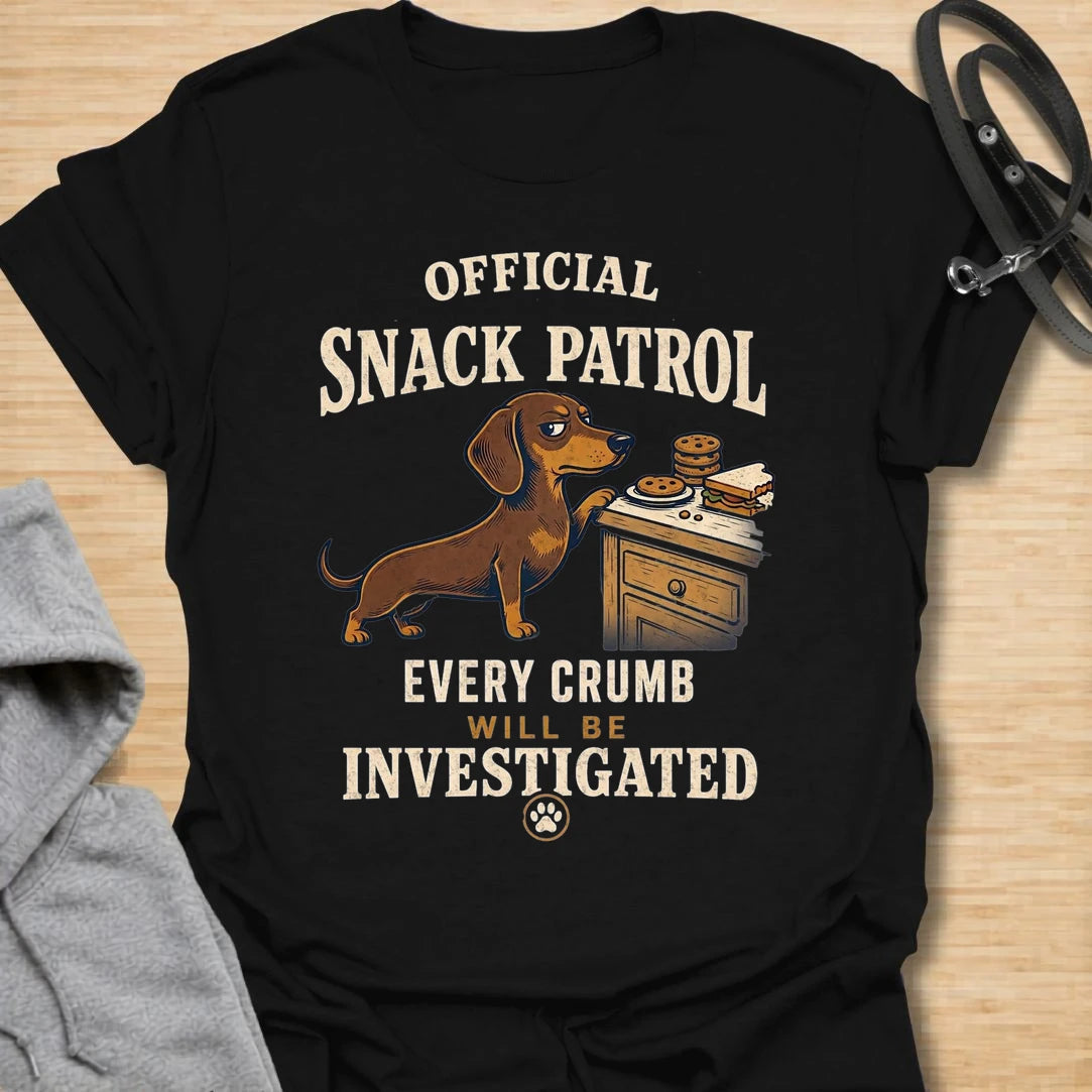 This Official Snack Patrol t-shirt is made for dachshund lovers who know no crumb, snack, or unattended plate is ever truly safe. Featuring a determined doxie investigating a bedside table full of treats with bold vintage-style text, this funny dog design is great for dachshund moms, dachshund dads, wiener dog fans, rescue dog lovers, and anyone whose little long dog takes snack supervision very seriously.