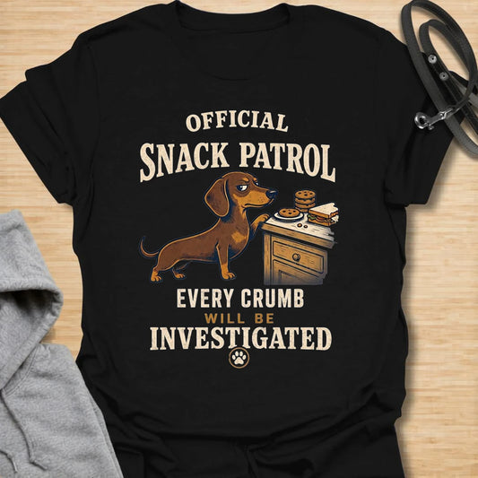 This Official Snack Patrol t-shirt is made for dachshund lovers who know no crumb, snack, or unattended plate is ever truly safe. Featuring a determined doxie investigating a bedside table full of treats with bold vintage-style text, this funny dog design is great for dachshund moms, dachshund dads, wiener dog fans, rescue dog lovers, and anyone whose little long dog takes snack supervision very seriously.