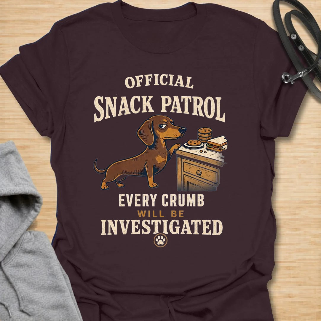 This Official Snack Patrol t-shirt is made for dachshund lovers who know no crumb, snack, or unattended plate is ever truly safe. Featuring a determined doxie investigating a bedside table full of treats with bold vintage-style text, this funny dog design is great for dachshund moms, dachshund dads, wiener dog fans, rescue dog lovers, and anyone whose little long dog takes snack supervision very seriously.