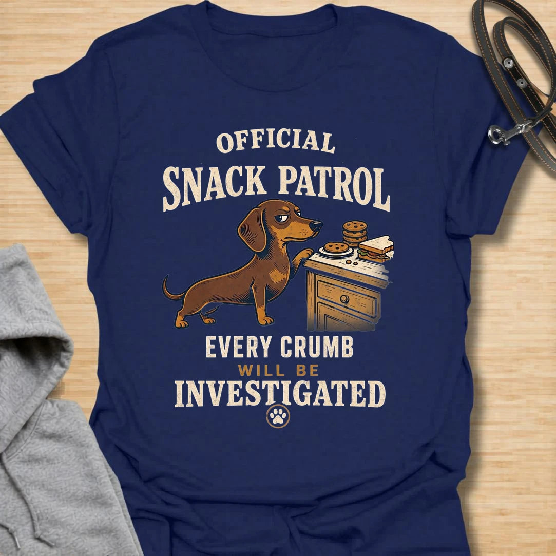 This Official Snack Patrol t-shirt is made for dachshund lovers who know no crumb, snack, or unattended plate is ever truly safe. Featuring a determined doxie investigating a bedside table full of treats with bold vintage-style text, this funny dog design is great for dachshund moms, dachshund dads, wiener dog fans, rescue dog lovers, and anyone whose little long dog takes snack supervision very seriously.