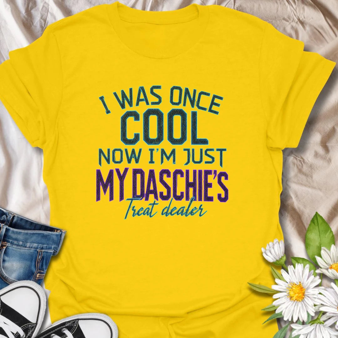 Life changes when a dachshund appoints you as the official treat dealer. This funny dachshund T-shirt is perfect for devoted daschie/doxie/daxie owners who know every snack request is urgent. A playful gift for dachshund moms, dads, and sausage dog lovers.