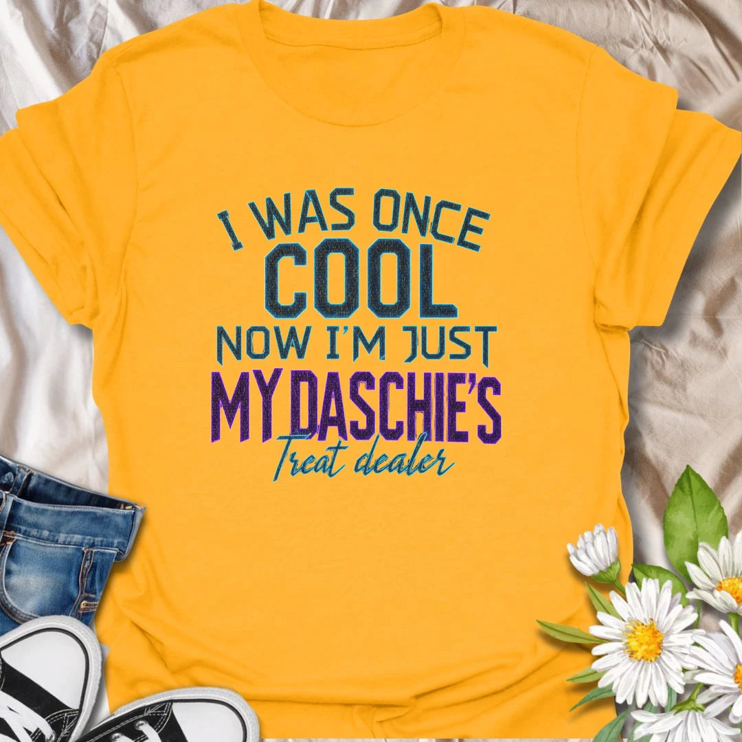 Life changes when a dachshund appoints you as the official treat dealer. This funny dachshund T-shirt is perfect for devoted daschie/doxie/daxie owners who know every snack request is urgent. A playful gift for dachshund moms, dads, and sausage dog lovers.