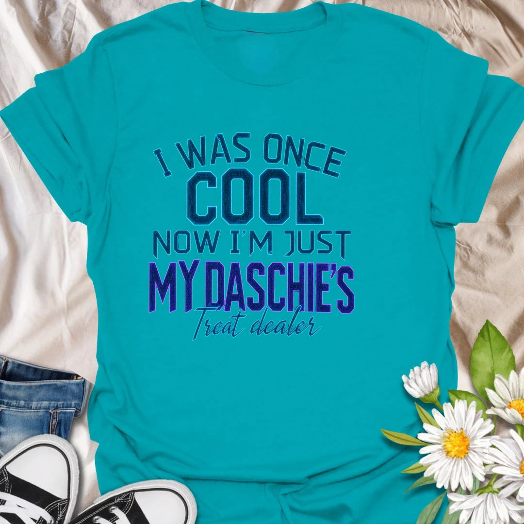 Life changes when a dachshund appoints you as the official treat dealer. This funny dachshund T-shirt is perfect for devoted daschie/doxie/daxie owners who know every snack request is urgent. A playful gift for dachshund moms, dads, and sausage dog lovers.