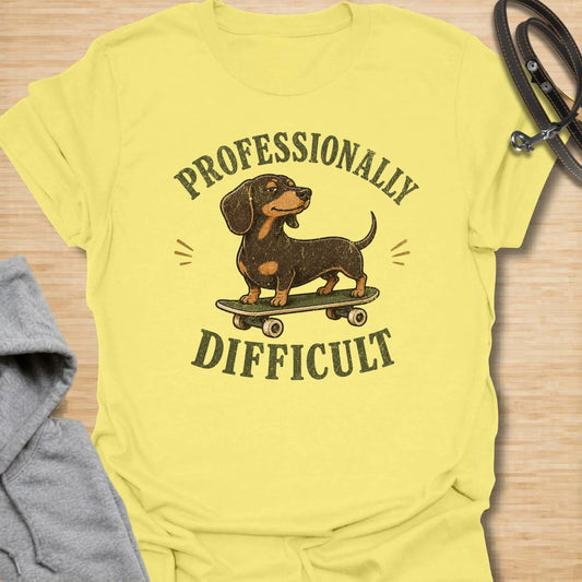 This Professionally Difficult t-shirt is made for dachshund lovers who know their little long dog has turned stubbornness into an art form. Featuring a smug dachshund standing on a skateboard with bold vintage-style lettering, this design has a funny breed-specific attitude. Perfect for dachshund moms, dachshund dads, wiener dog fans, rescue dog lovers, and anyone whose doxie is adorable but absolutely not easy.