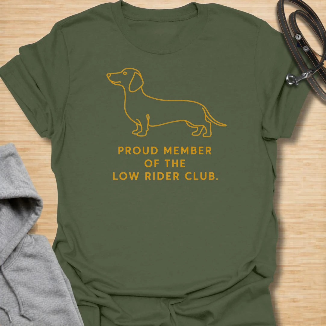 This Proud Member Of The Low Rider Club t-shirt is made for dachshund lovers who celebrate tiny legs, long bodies, and big personality. Featuring a simple dachshund line illustration with bold club-style lettering, this design has a clean, classic dog-parent feel. Perfect for dachshund moms, dachshund dads, wiener dog fans, rescue dog lovers, and anyone proudly part of the low rider club.