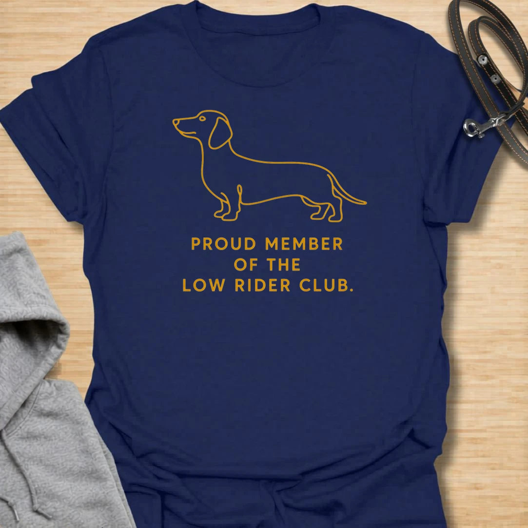 This Proud Member Of The Low Rider Club t-shirt is made for dachshund lovers who celebrate tiny legs, long bodies, and big personality. Featuring a simple dachshund line illustration with bold club-style lettering, this design has a clean, classic dog-parent feel. Perfect for dachshund moms, dachshund dads, wiener dog fans, rescue dog lovers, and anyone proudly part of the low rider club.