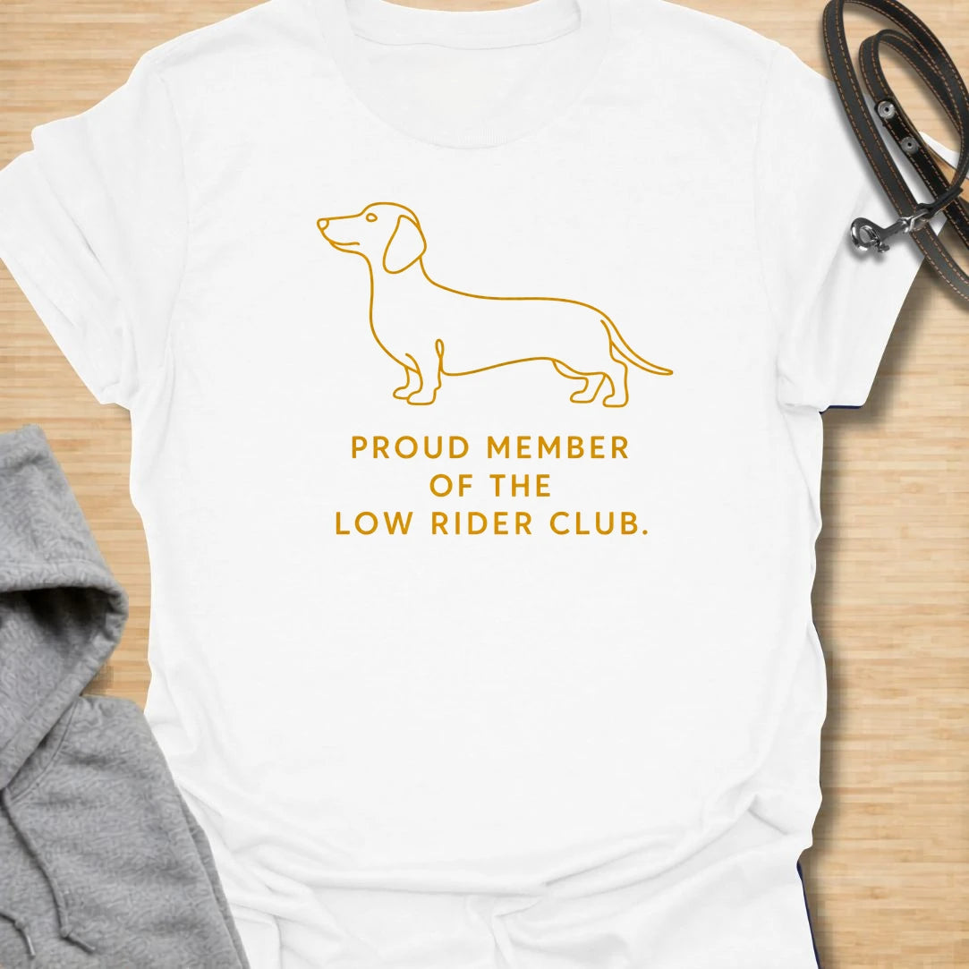 This Proud Member Of The Low Rider Club t-shirt is made for dachshund lovers who celebrate tiny legs, long bodies, and big personality. Featuring a simple dachshund line illustration with bold club-style lettering, this design has a clean, classic dog-parent feel. Perfect for dachshund moms, dachshund dads, wiener dog fans, rescue dog lovers, and anyone proudly part of the low rider club.