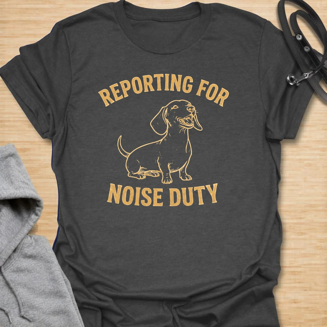 This Reporting For Noise Duty t-shirt is made for dachshund lovers who know their little long dog takes barking very seriously. Featuring a bold one-color dachshund illustration with strong simple lettering, this design has a funny breed-specific feel that doxie owners will instantly understand. Perfect for dachshund moms, dachshund dads, wiener dog fans, rescue dog lovers, and anyone living with a tiny self-appointed alarm system.