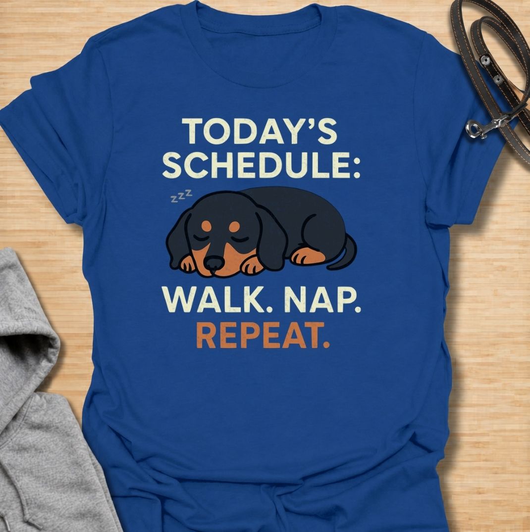 A funny dachshund T-shirt for anyone familiar with the very demanding daily routine of a sausage dog. Featuring the phrase “Today’s Schedule: Walk. Nap. Repeat.” with a sleepy dachshund illustration, this design captures the breed’s love of short adventures followed by serious rest. Perfect for dachshund moms, dachshund dads, wiener dog owners, and anyone whose dog has mastered the art of doing just enough. A playful everyday tee for fans of dachshund humor, lazy dog jokes, and breed-specific gifts.