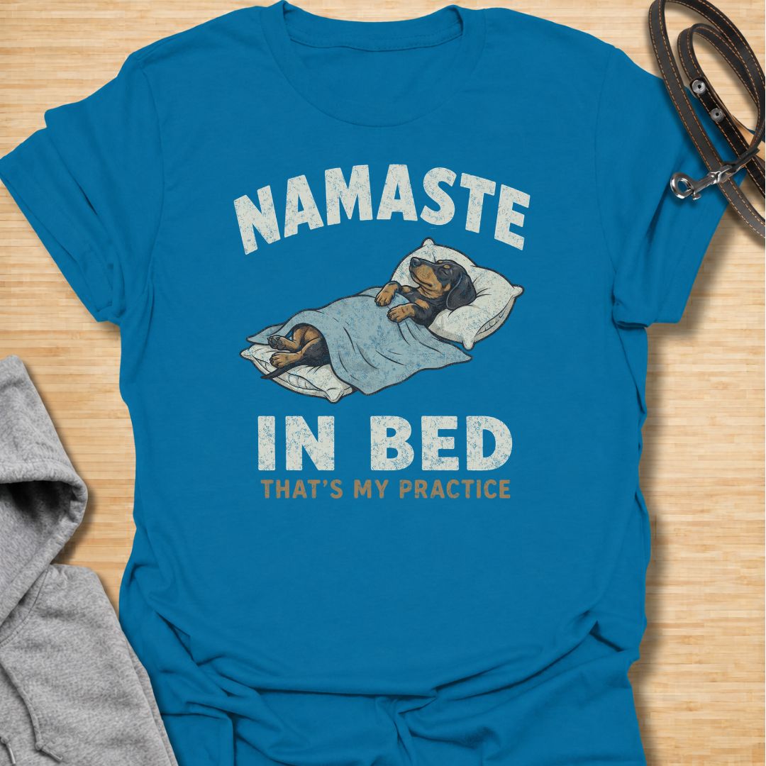 Celebrate the dachshund approach to yoga with this funny “Namaste in Bed” T-shirt. Featuring a cozy sausage dog tucked beneath the blankets with the phrase “That’s My Practice,” it is perfect for dachshund moms, dog dads, homebodies, and yoga lovers. A playful gift for anyone who prefers relaxation, naps, and staying comfortably in bed.