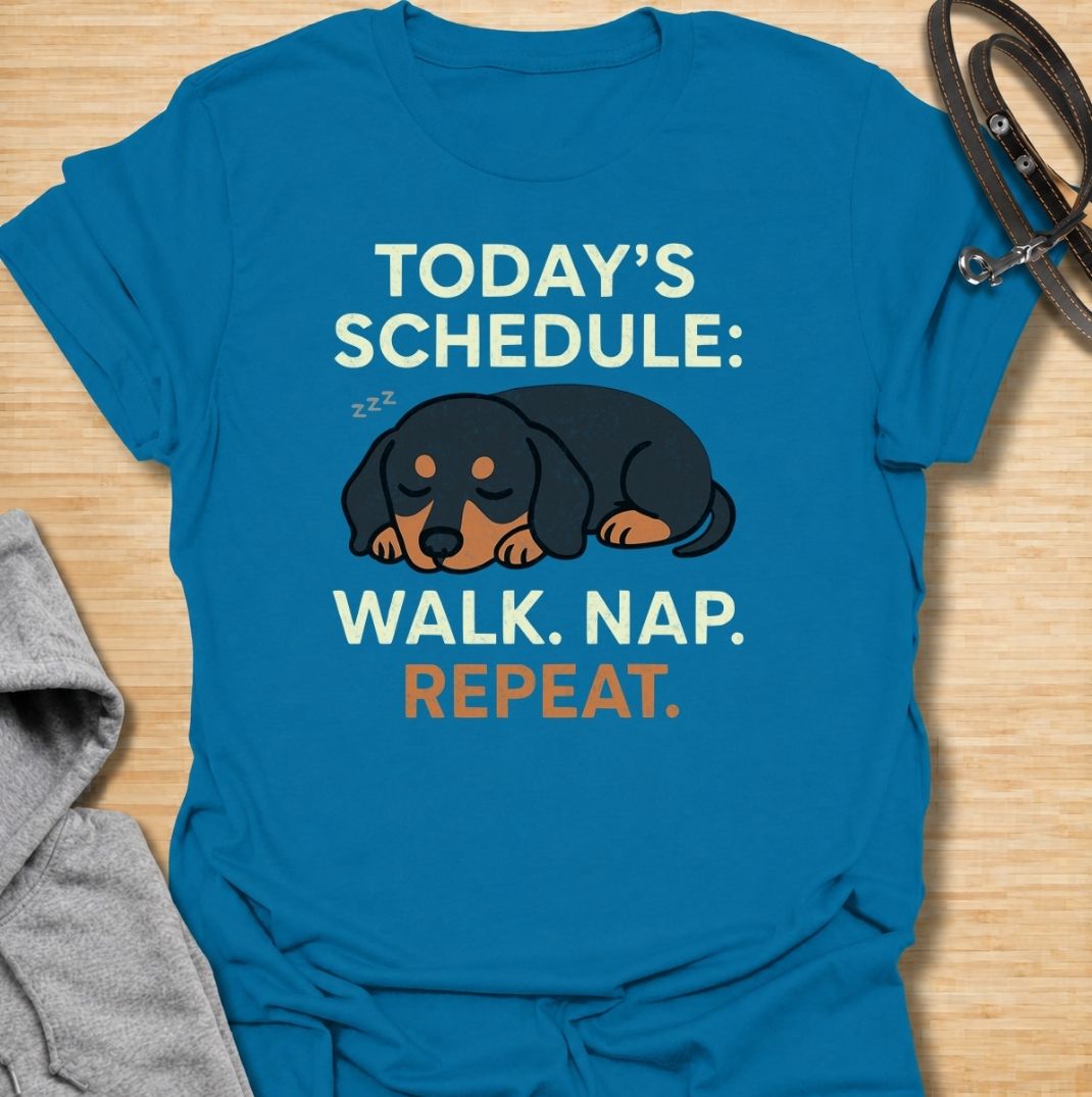 A funny dachshund T-shirt for anyone familiar with the very demanding daily routine of a sausage dog. Featuring the phrase “Today’s Schedule: Walk. Nap. Repeat.” with a sleepy dachshund illustration, this design captures the breed’s love of short adventures followed by serious rest. Perfect for dachshund moms, dachshund dads, wiener dog owners, and anyone whose dog has mastered the art of doing just enough. A playful everyday tee for fans of dachshund humor, lazy dog jokes, and breed-specific gifts.