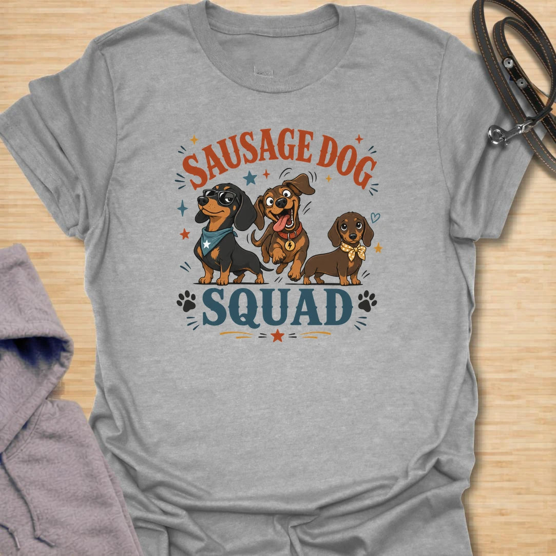 Sausage Dog Squad t-shirt for dachshund lovers who know every doxie has a very different personality. The playful design features three funny dachshunds with big expressions, bold lettering, and plenty of chaotic little-dog charm. It is perfect for dachshund moms, doxie dads, wiener dog fans, and anyone who loves breed-specific dog humor. A fun gift for dachshund owners whose tiny long dogs act like the whole neighborhood belongs to them.