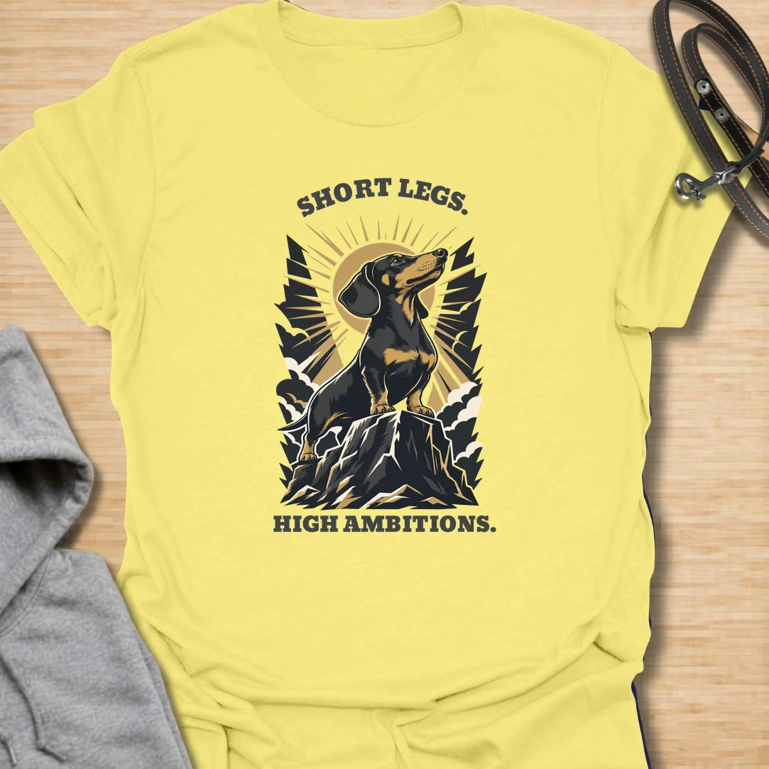 Short Legs High Ambitions t-shirt for dachshund lovers who know tiny legs never mean tiny confidence. This bold mountain-style design features a proud dachshund standing tall with dramatic vintage outdoor energy. A great gift for dachshund moms, dachshund dads, hikers, dog lovers, and anyone who loves a determined little sausage dog. Perfect for everyday wear, dog walks, casual weekends, or showing off big doxie attitude.