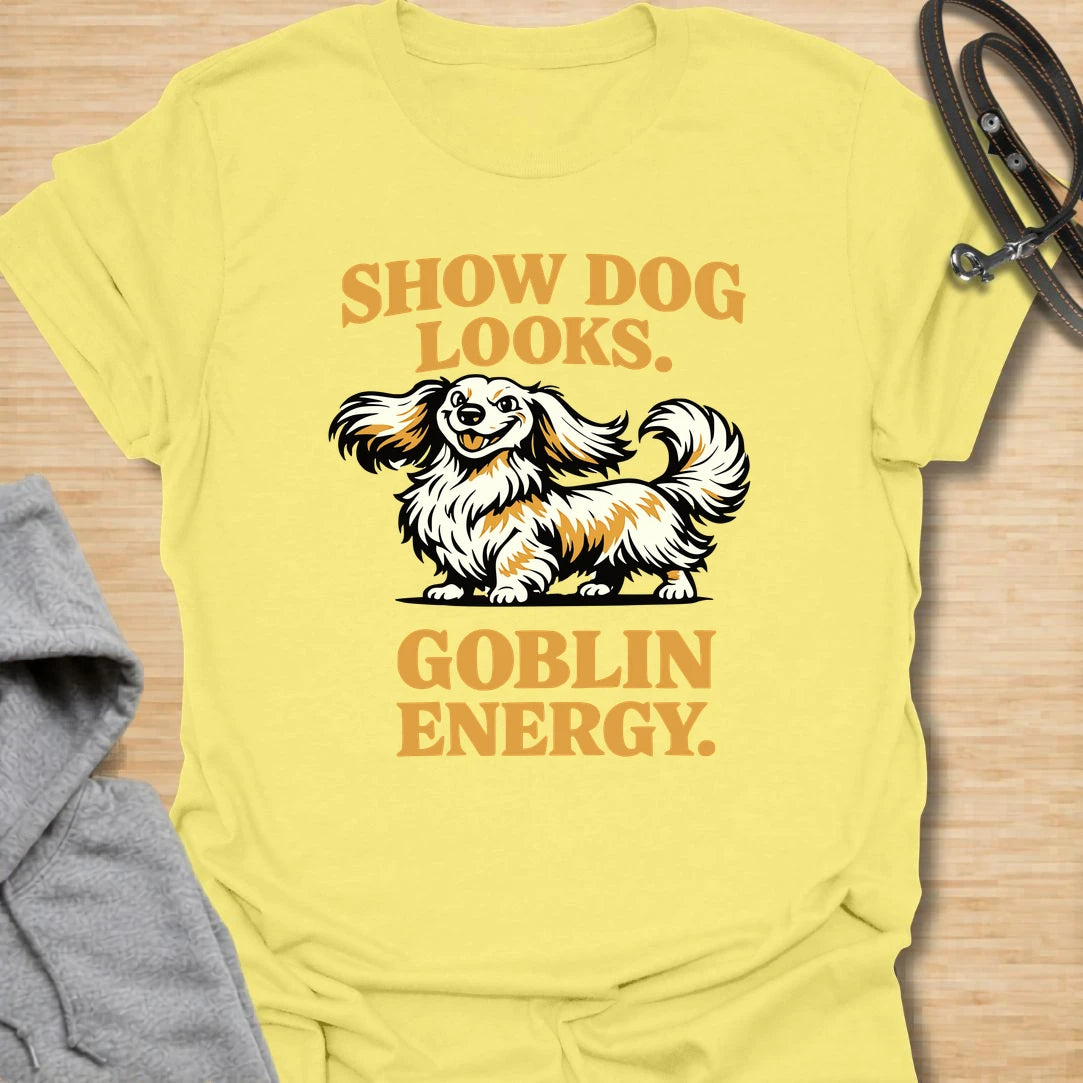 This Show Dog Looks Goblin Energy t-shirt is made for long-haired dachshund lovers who know their elegant little dog can look polished and still act completely unhinged. Featuring a fluffy long-haired doxie with bold retro lettering, this design has a funny breed-specific feel that dachshund owners will instantly understand. Perfect for dachshund moms, dachshund dads, long-haired doxie fans, rescue dog lovers, and anyone whose pretty dog has pure goblin energy.