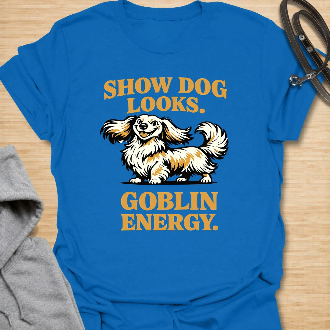 This Show Dog Looks Goblin Energy t-shirt is made for long-haired dachshund lovers who know their elegant little dog can look polished and still act completely unhinged. Featuring a fluffy long-haired doxie with bold retro lettering, this design has a funny breed-specific feel that dachshund owners will instantly understand. Perfect for dachshund moms, dachshund dads, long-haired doxie fans, rescue dog lovers, and anyone whose pretty dog has pure goblin energy.
